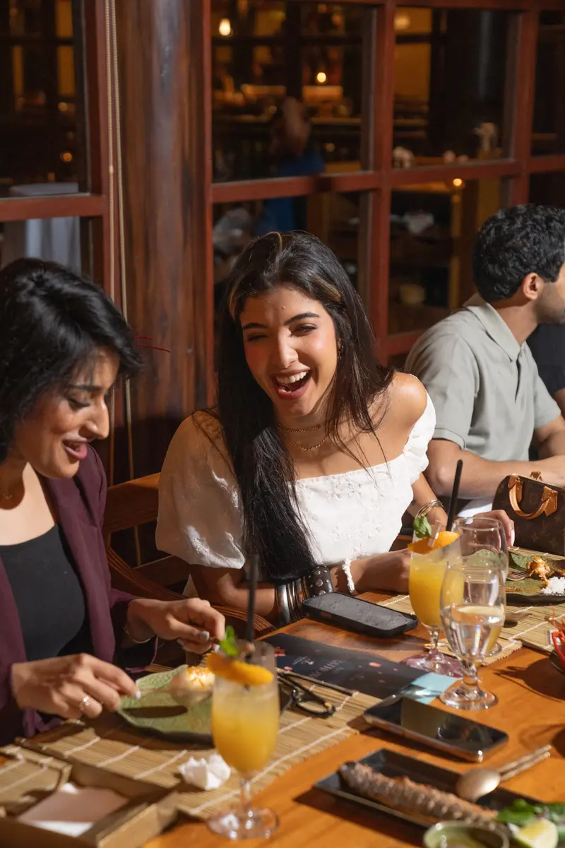 Members laughing at a Palm & Plate dinner